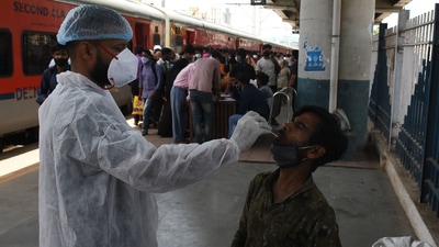 A BMC health worker collects swab samples for Covid-19 test of commuters arriving from outstation trains at Dadar station, in Mumbai. A BMC health worker collects swab samples for Covid-19 test of commuters arriving from outstation trains at Dadar station, in Mumbai.