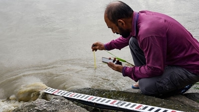 An employee of Central Water Commission (CWC) measures the temperature of the Brahmaputra river's water, which is flowing above the danger level, in Guwahati. (PTI) An employee of Central Water Commission (CWC) measures the temperature of the Brahmaputra river's water, which is flowing above the danger level, in Guwahati. (PTI)