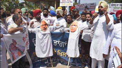 AAP workers protesting against BJP and Haryana CM Manohar Lal Khattar outside the mini secretariat in Ludhiana on Tuesday. (Gurpreet Singh/HT)