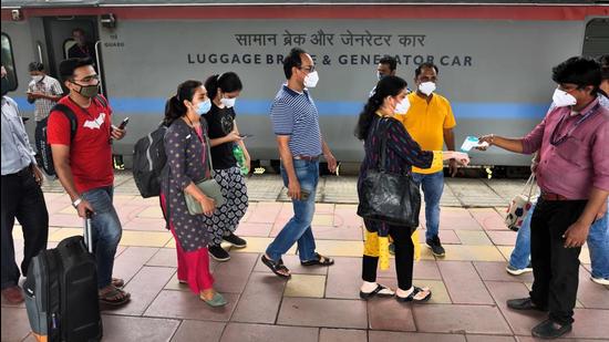 A health worker checking temperature of passengers at Dadar Station in Mumbai. (Satish Bate/HT Photo)