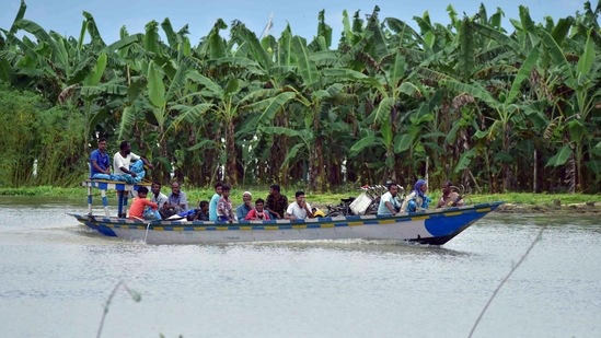 Locals use a boat to move across a flooded locality at Laokhowa, in Nagaon.(ANI)
