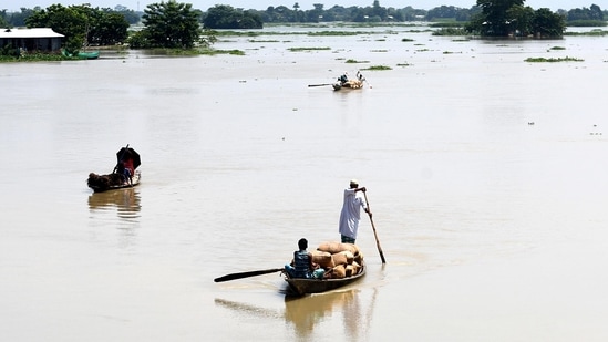 Locals row their boats with their belongings to move to a safer place after the floodwater enters the village amid heavy rainfall, in Morigaon.(ANI)
