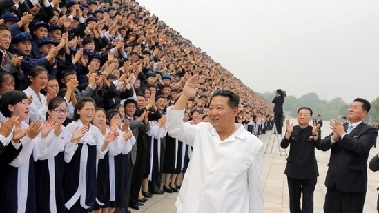 Kim Jong Un waves as he attends a photo session with participants during Youth Day celebrations. 