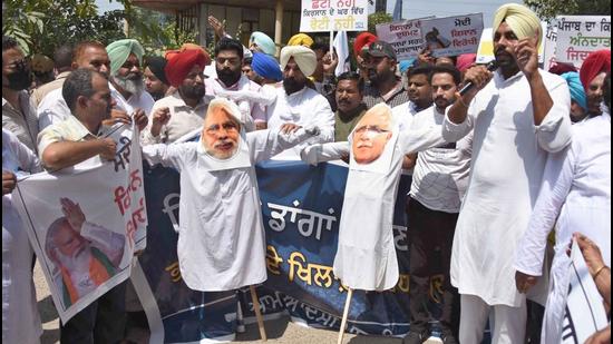 AAP workers protesting against BJP and Haryana CM Manohar Lal Khattar outside the mini secretariat in Ludhiana on Tuesday. (Gurpreet Singh/HT)