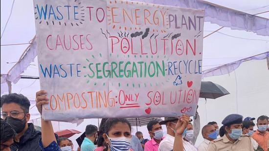 The hearing took place under a makeshift canopy at the foothills of the Bandhwari landfill, amid rain and heavy police presence. At least 150 citizens attended the meeting to voice their concerns about a WTE plant. (Parveen Kumar/HT Photo)