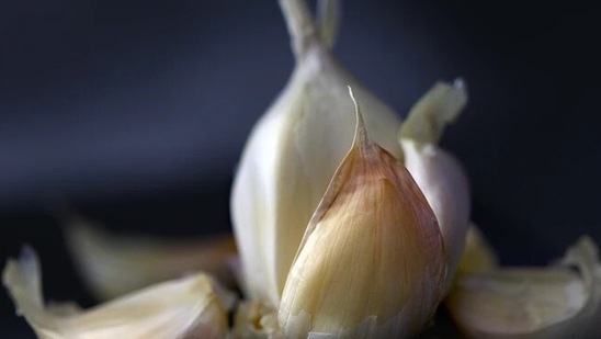 Garlic: Garlic has a compound called allicin having antibacterial and antimicrobial properties which helps destroy the bacteria causing the toothache. You can either chew it directly or apply it as a paste by mixing rock salt in it.(Unsplash)