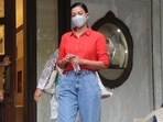 Gauahar Khan in a red shirt and blue jeans, clicked by the paparazzi.