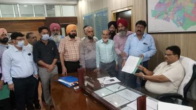 Members of MC employees’ union submitting a memorandum with MC Commissioner Sabharwal seeking cancellation of the FIR in Ludhiana on Wednesday. (HT Photo)