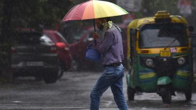 A commuter with an umbrella in rain at Sector 12, Noida. (Sunil Ghosh/HT Photo) A commuter with an umbrella in rain at Sector 12, Noida. (Sunil Ghosh/HT Photo)