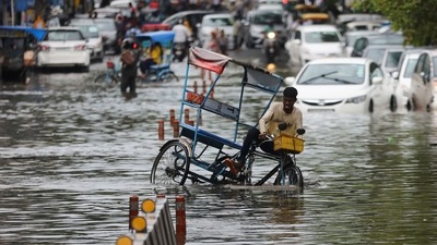 A man riding his cycle-rickshaw stumbles on a waterlogged street after heavy rains in New Delhi. (REUTERS)