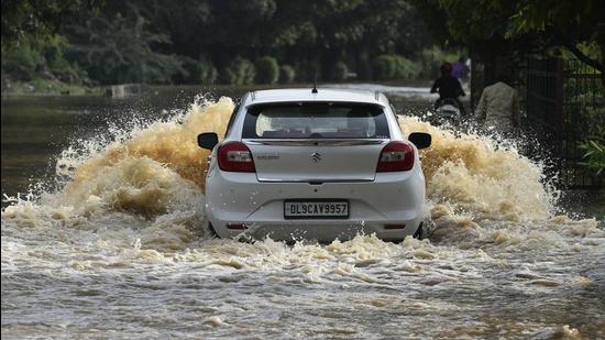Vehicles wade through a waterlogged stretch near Sector 22 in Delhi’s Dwarka locality. (Vipin Kumar/HT PHOTO)