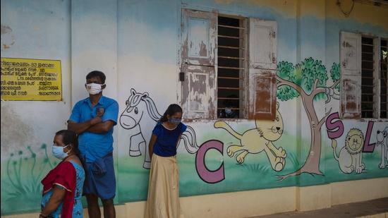 People wearing masks wait to get vaccinated for Covid-19 outside a school in Kochi, Kerala on Wednesday. (AP) People wearing masks wait to get vaccinated for Covid-19 outside a school in Kochi, Kerala on Wednesday. (AP)