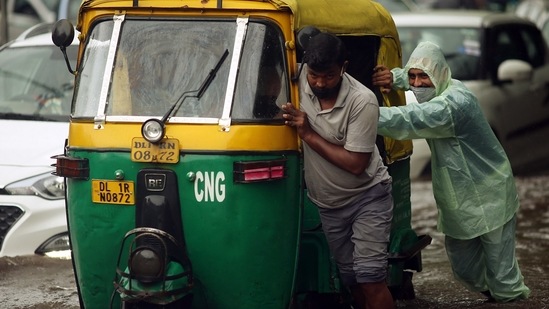 People push an autorickshaw on a waterlogged road during heavy rainfall, in New Delhi on September 1. (ANI)