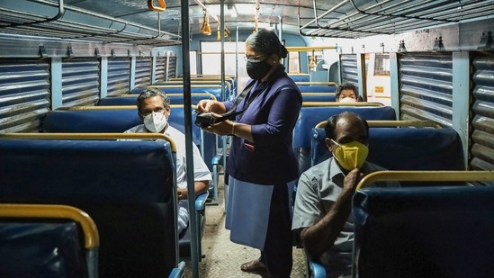 A lady conductor issues tickets to customer during start of Kerala RTC services, after relaxations in COVID-19 lockdown, in Kozhikode. (PTI Photo)