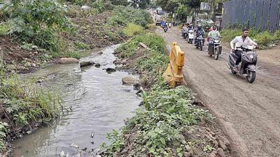 Commuters travel on the unfinished road near the D-Mart at Ambegaon Budruk, which is running by an open nallah and has already seen many accidents happen. (Rahul Raut/HT PHOTO)