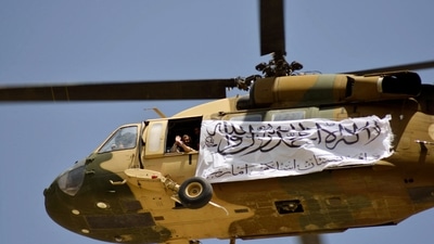 A helicopter displaying a Taliban flag flies above Kandahar on September 1. (AFP Photo)
