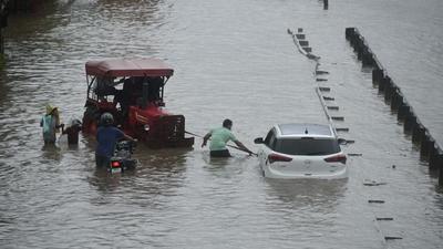 People push a car through a heavily waterlogged road at NH-48 in Gurugram on Wednesday (Parveen Kumar/HT photo) People push a car through a heavily waterlogged road at NH-48 in Gurugram on Wednesday (Parveen Kumar/HT photo)