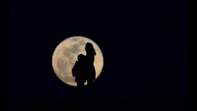Lunar cycle: A woman and a child silhouetted against the moon. (Soner Kilinc/Getty Images) Lunar cycle: A woman and a child silhouetted against the moon. (Soner Kilinc/Getty Images)