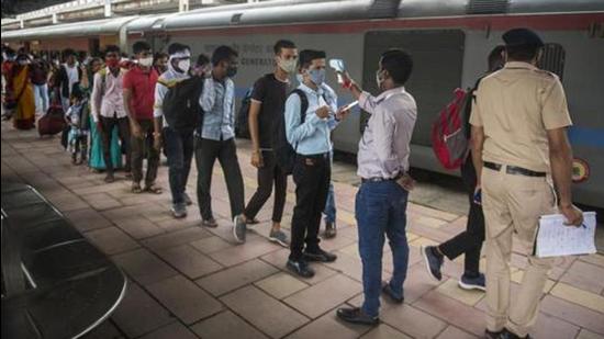 A healthcare worker checks temperatures before Covid-19 test of the passengers arriving from outstation trains at Dadar station in Mumbai on August 25. (HT file photo)
