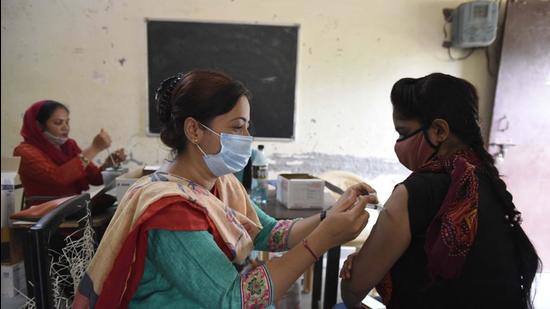 A health worker administers a dose of the Covid-19 vaccine to a beneficiary at a government primary school in Shivaji Nagar in Gurugram on August 31 (Parveen Kumar/HT photo) A health worker administers a dose of the Covid-19 vaccine to a beneficiary at a government primary school in Shivaji Nagar in Gurugram on August 31 (Parveen Kumar/HT photo)