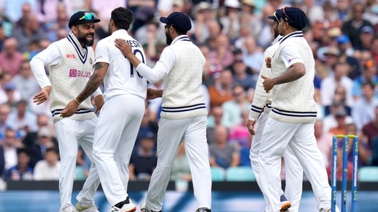 India's Virat Kohli, left, and India's Umesh Yadav, second left, celebrate taking the wicket of England's Dawid Malan on day two of the fourth Test match at The Oval cricket ground in London, Friday, Sept. 3, 2021. (AP)