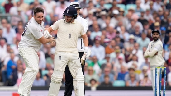 A pitch invader dressed in whites, left, bumps into England's Jonny Bairstow on day two of the fourth Test match at The Oval cricket ground in London, Friday, Sept. 3, 2021.(AP)