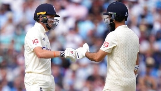 England's Ollie Pope, left, celebrates with England's Moeen Ali as they add runs during their partnership on day two of the fourth Test match at The Oval cricket ground in London, Friday, Sept. 3, 2021.(AP)