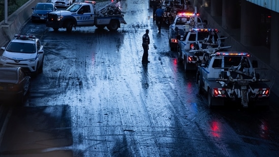 A member of the NYPD supervises tow trucks clearing cars abandoned on the Major Deegan Expressway.(REUTERS)