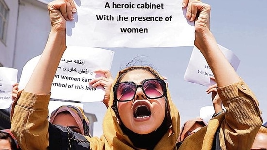 A woman holds up a protest message as she demonstrates, along with several other women, in front of the presidential palace in Kabul on Friday. The protesters called upon the Taliban regime to respect and preserve women’s rights.(Reuters)