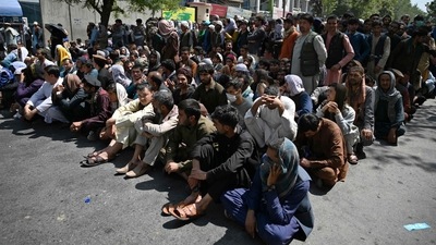 People sit along a road outside a bank waiting to withdraw money at Shar-e-Naw neighbourhood in Kabul (AFP) People sit along a road outside a bank waiting to withdraw money at Shar-e-Naw neighbourhood in Kabul (AFP)