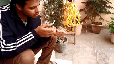 Man feeling a baby squirrel using a dropper. (Jukin Media)