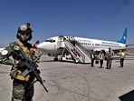 A Taliban soldier stands guard as passengers disembark at Kabul airport.(AP) A Taliban soldier stands guard as passengers disembark at Kabul airport.(AP)