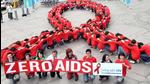Dozens of volunteers join a human chain in the form of a red ribbon, a symbol of Dozens of volunteers join a human chain in the form of a red ribbon, a symbol of