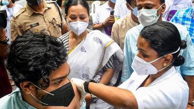 A medic administers a dose of the Covid-19 vaccine to a beneficiary in the presence of Kerala Minister for Health Veena George during the state's first drive-through vaccination at the Government Women’s College in Thiruvananthapuram recently. (PTI PHOTO.)