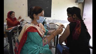 A health worker administers a dose of Covid-19 vaccine to a beneficiary, at a government primary school in Gurugram. (HT FILE)