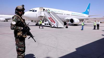 A member of Taliban forces stands guard next to a plane at Hamid Karzai International Airport in Kabul on Sunday. (REUTERS) A member of Taliban forces stands guard next to a plane at Hamid Karzai International Airport in Kabul on Sunday. (REUTERS)