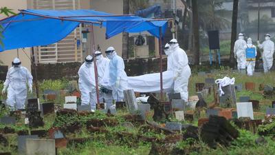 Health workers bury the body of a 12-year-old Nipah virus victim at Kannamparambu cemetery in Kozhikode on Sunday. (PTI PHOTO.) Health workers bury the body of a 12-year-old Nipah virus victim at Kannamparambu cemetery in Kozhikode on Sunday. (PTI PHOTO.)