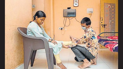 Sandip Bilewar (right), a visually challenged physiotherapist, working on his patient in Ambernath. (HT Photo)