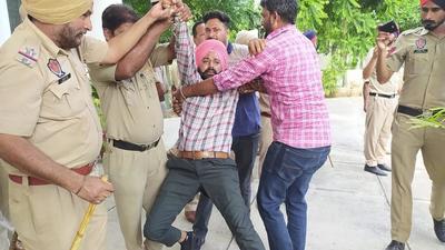Police forcibly removing Unemployed Physical Training Instructors (PTI) teachers from the PWD Rest House in Sangrur on Sunday. (HT Photo)