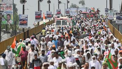 Farmers representing various unions and their supporters march towards a ground during a mahapanchayat or a huge gathering in Muzaffarnagar on Sunday. (AFP) Farmers representing various unions and their supporters march towards a ground during a mahapanchayat or a huge gathering in Muzaffarnagar on Sunday. (AFP)