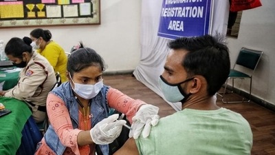A health worker administers a Covid-19 vaccine shot to a man at a inoculation centre on DDU Marg in Delhi (Sanchit Khanna/ Hindustan Time)