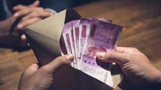 Businessman counting money, Indian Rupee currency, in the envelope just given by his partner after making an agreement in private dark room - loan, briberry and corruption scam concepts (Getty Images/iStockphoto)