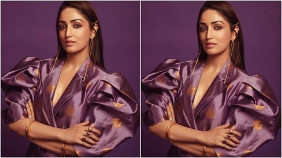 Today, Yami gave a glimpse of another look for which she wore a printed purple attire highlighted with exaggerated sleeves, gold brocade embroidery and a notch-lapel collared front. She teamed the outfit with gold jewels and open tresses.(Instagram/@yamigautam)