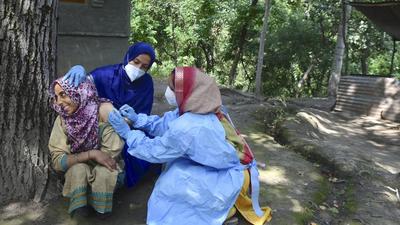 A health worker administers a dose of Covid vaccine to a woman during a special vaccination drive at Mamgund Gonipora village in Budgam district. (File photo) A health worker administers a dose of Covid vaccine to a woman during a special vaccination drive at Mamgund Gonipora village in Budgam district. (File photo)
