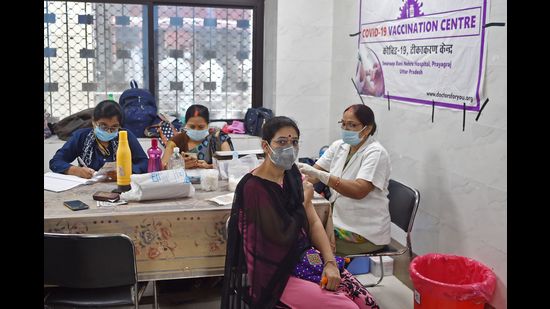 A medical worker (R) inoculates a woman with a dose of the Covishield vaccine against the Covid-19 coronavirus at a hospital in Allahabad on September 6, 2021. (Photo by Sanjay KANOJIA / AFP) (AFP)