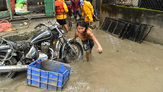 A girl walks through a street which was flooded after Bishnumati river overflowed following heavy monsoon rains in Kathmandu(AFP) A girl walks through a street which was flooded after Bishnumati river overflowed following heavy monsoon rains in Kathmandu(AFP)