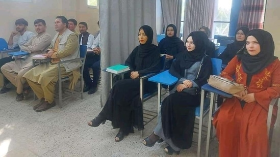 Students at a university in Afghanistan are seen studying separated by a curtain on Monday.(Twitter/@AamajN)