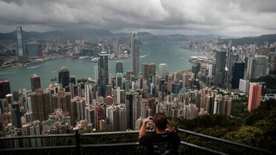 A visitor sets up his camera in the Victoria Peak area to photograph Hong Kong's skyline. Travellers arriving in Hong Kong from China will no longer need to quarantine. (AP Photo/Jae C. Hong, File) A visitor sets up his camera in the Victoria Peak area to photograph Hong Kong's skyline. Travellers arriving in Hong Kong from China will no longer need to quarantine. (AP Photo/Jae C. Hong, File)