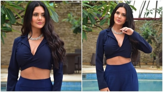 Esha chose a coordinated navy blue outfit for the promotional event. She flaunted her washboard abs in a collared full-sleeve crop blouse with a draping effect on the front and matching high-waist flared pants.(HT Photo/Varinder Chawla)
