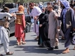 A member of the Taliban forces points his gun at protesters, as Afghan demonstrators shout slogans during an anti-Pakistan protest.
